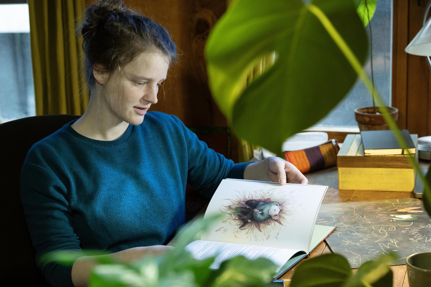 Stien Van Kerckhoven bladert door het kinderboek dat ze illustreerde.