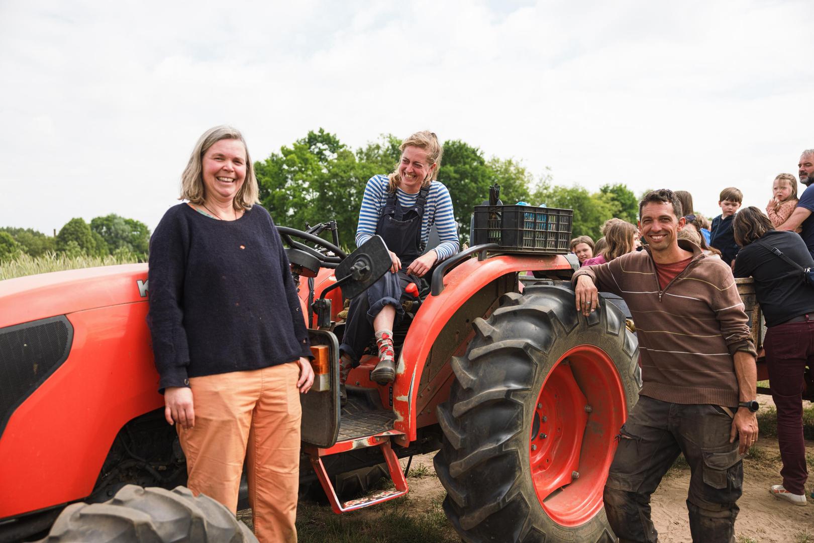 De oprichters van Loof & Bezen: Kaat Segers, Ona Meirlaen en Tom Cnudde bij de tractor. Enkele weken geleden organiseerde het trio een opendeurdag op de bioboerderij.