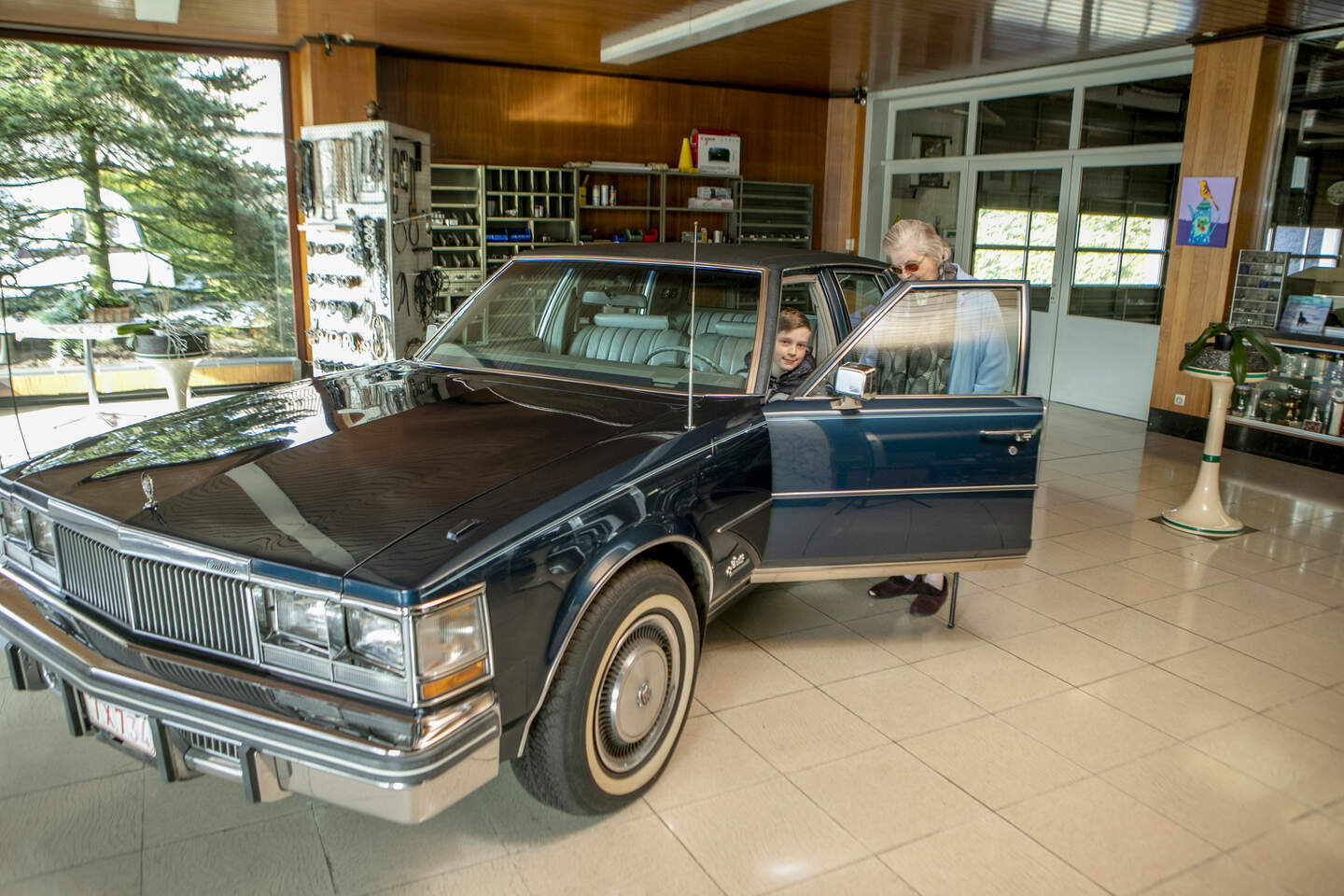 Maria poseert bij haar Cadillac in de toonzaal van de Garage Dankers.