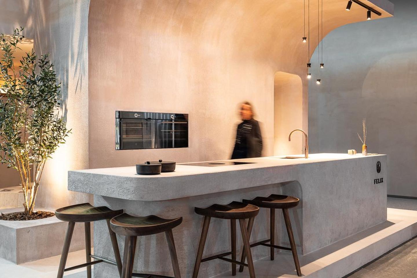 Het microbeton van muren, vloer, keukeneiland en werkblad gaan in dit interieur naadloos in elkaar over. 