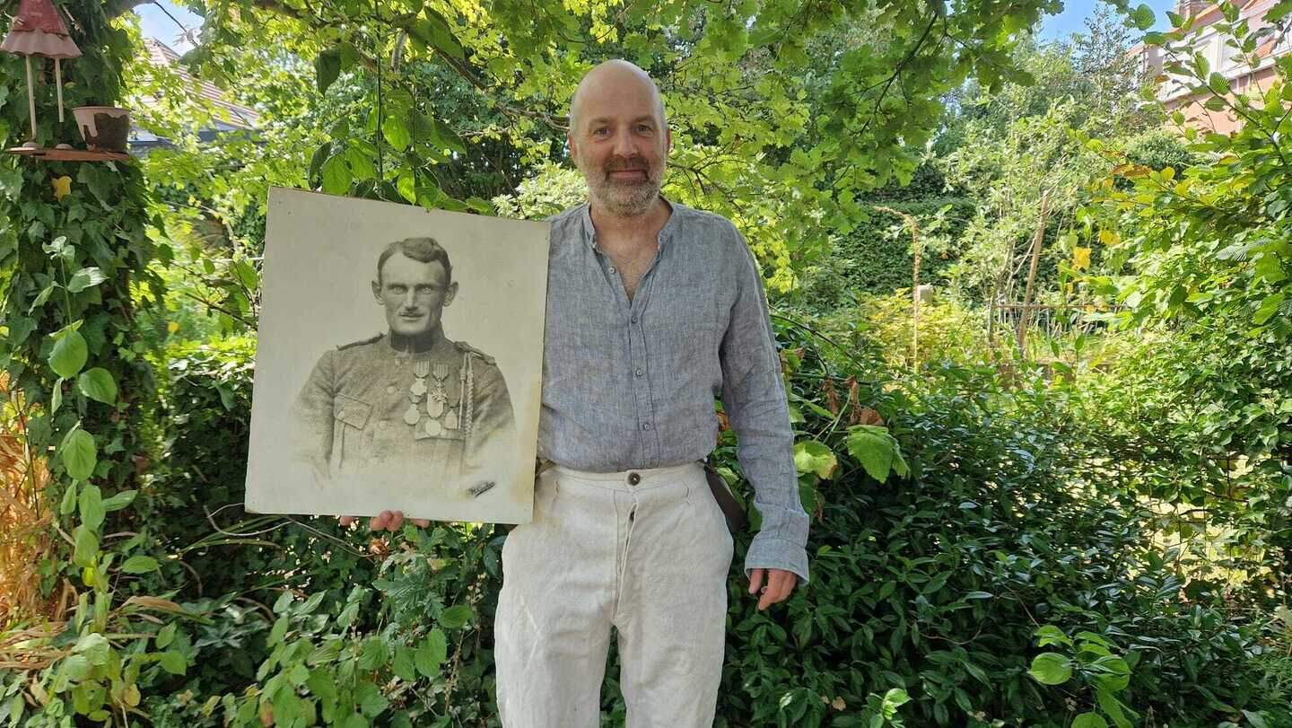 Bart Geraets met een portret van zijn grootvader en de kledij zoals het toen zou kunnen zijn geweest.