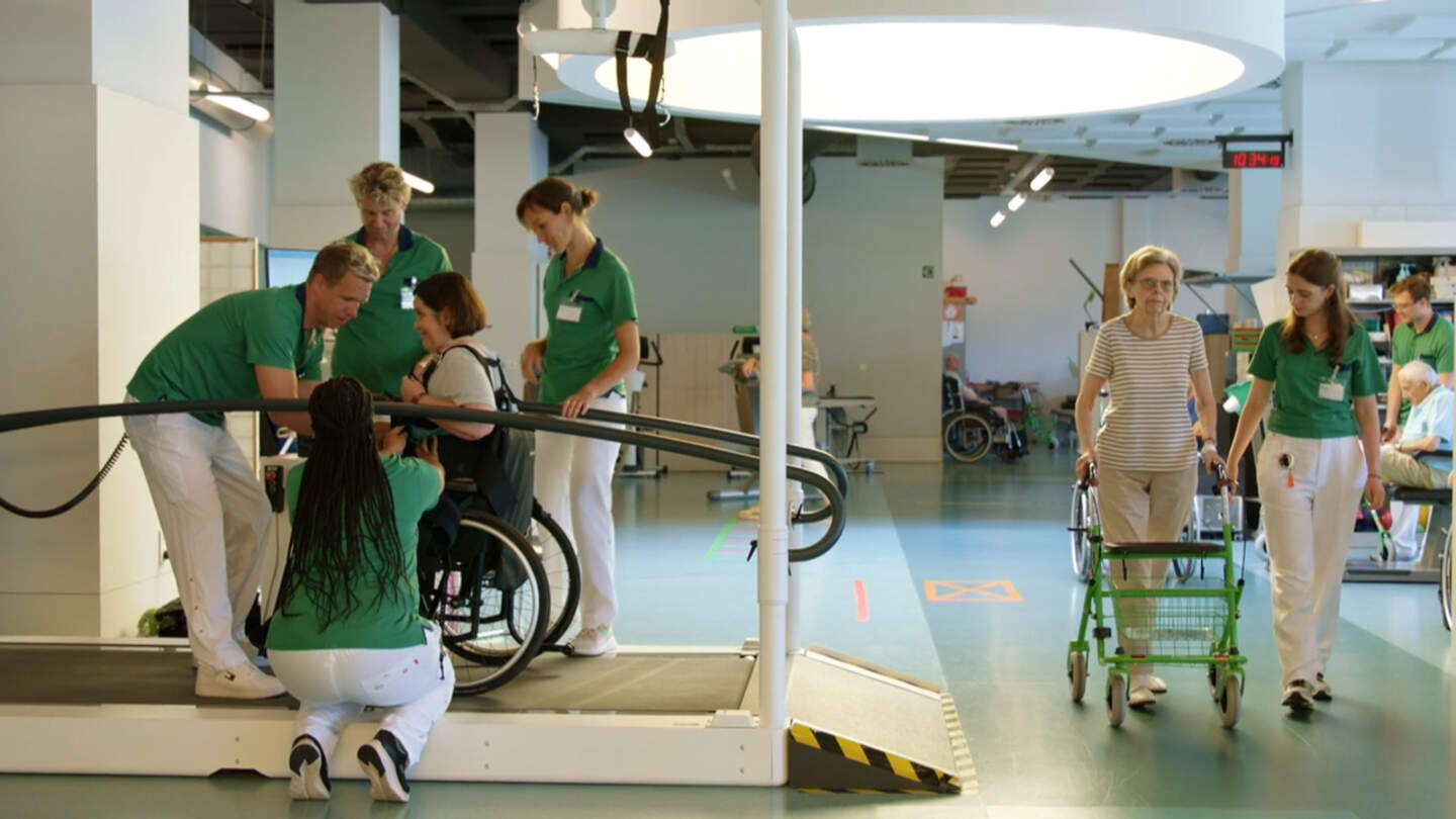 Patiënten leren weer lopen via een loopband.